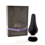 Buttplug in luxe doosje, zwarte siliconen buttplug naast donkergrijze geschenkdoos met paars lint.